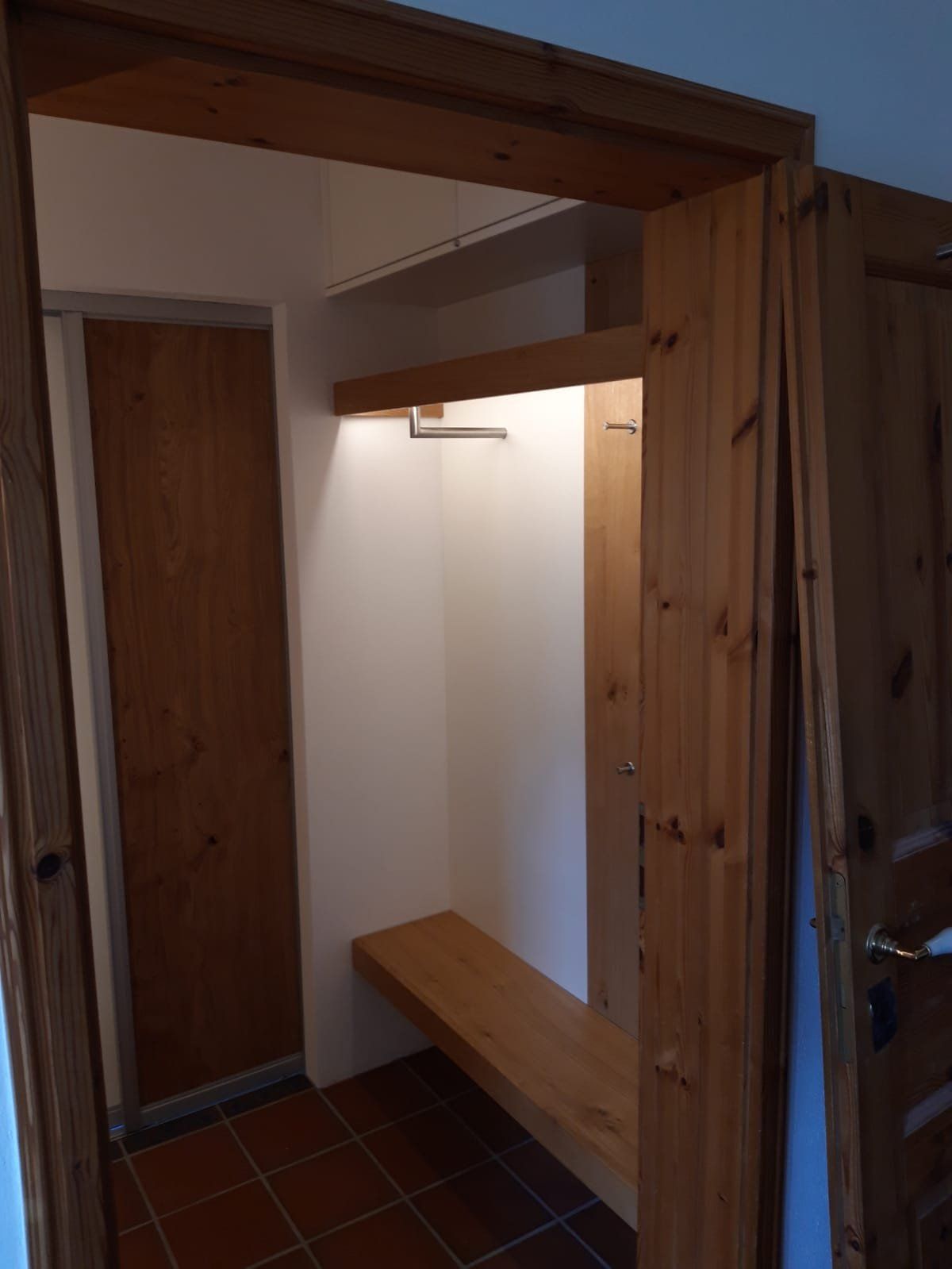 Hausflur mit Holzrahmen, Sitzbank und Ablage aus Holz als Garderobe
